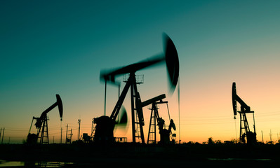 Oil pumps in action, silhouetted against the setting sun