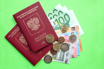 Two Russian foreign passports and euro notes of various denominations and Eurocent on a green background