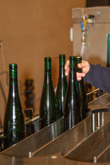 in a winery automatically filled bottles are taken off from the filling station
