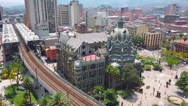 Orbiting aerial 4k shot of Plaza Botero and metro in summer day in Medellin