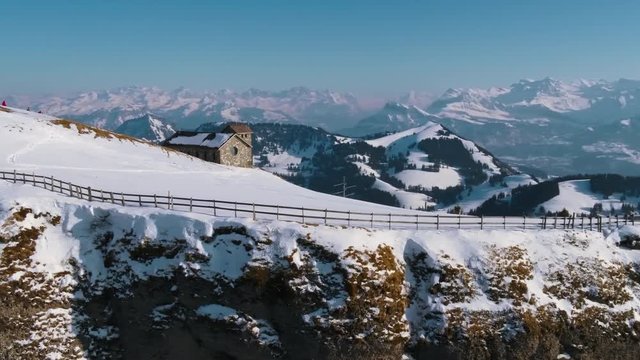 A drone movie along a mountain cliff with a stuning scenic view.
A fantastic movie on a winterday in the mountains.
There is also a little house visible on the top of the mountain.