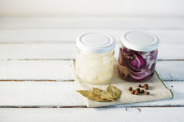 Glass Jar of Pickled Onions on White wood Background