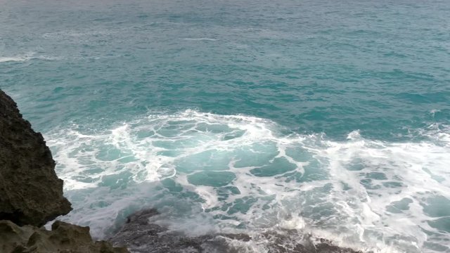 Gorgeous panning shot of waves crashing into a rocky shoreline