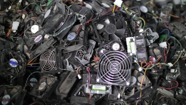 Close up of computer components being thrown on the stack for recycling