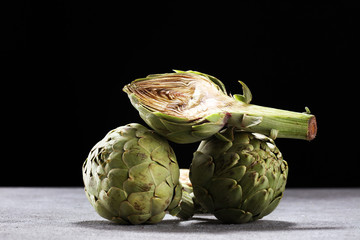 Obraz premium artichokes on rustic background. fresh organic artichoke flower set