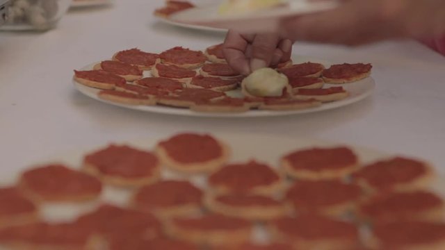 Cook preparing eggs with bread and sobrasada for event, typical Spanish food