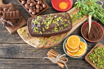 Cake with chocolate , cocoa , flour and hazelnut on the rustic wooden table