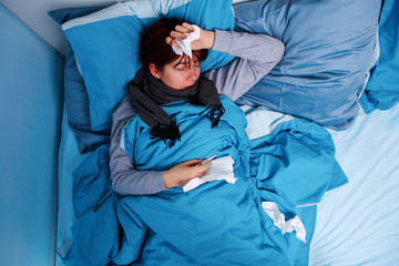 Photo of sick brunette lying in bed