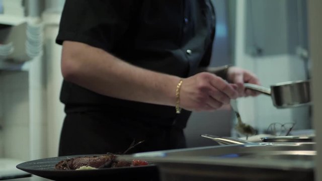 Chef Drizzles Sauce While Plating Up Gourmet Food for Service.