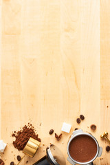 Assorted coffee beans, ground coffee, portafilter and tamper on wooden background. Top view of coffee background. Flat lay. Copy space for text. Barista concept.