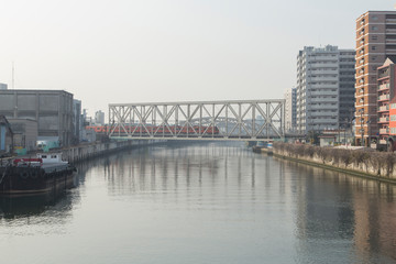 Cityscape with river, bridges, train and buildings in Osaka in spring clear day