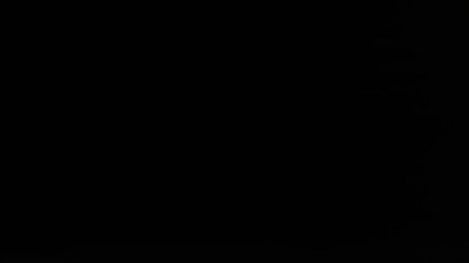 Silhouette Walking In Front of a Metal Roll Up Storage Door in a Warehouse During a Rave.