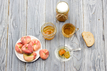 Peach jam, tea and bread close-up on a wooden table