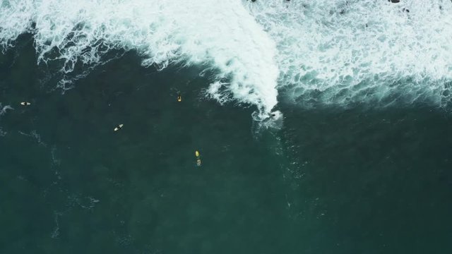 Top down drone shot of a surfen surfing on a wave