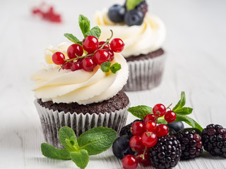 Chocolate cupcakes with delicate cream and fresh berries