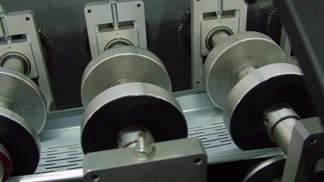 Closeup of rollers that feed the automatic production line in a metal cable tray fabrication shop