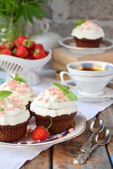 Chocolate cupcake with vanilla cream and strawberries. Vintage style