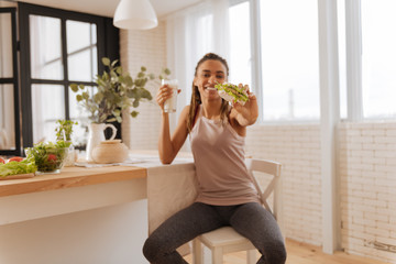 Woman wearing leggings and sport top enjoying healthy snack