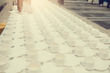 A lot of white coffee cups on white table