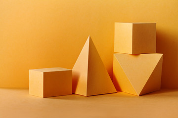 Yellow geometrical figures still life composition. Three-dimensional prism pyramid rectangular cube...