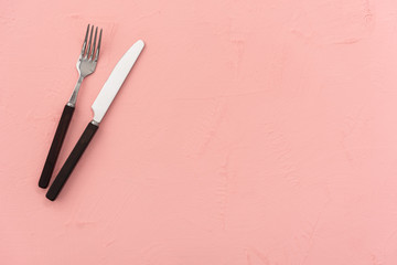 pastel pink background with knife and spoon food 