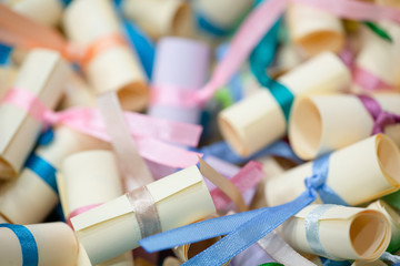 Pile of small paper scrolls White scrolls tied with blue and pink ribbon. Future prediction, advice or sign concept