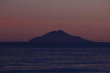 Naklejka na ściany i meble Sunset over Montecristo island from Marina di Campo beach, Elba island, Tuscany, Italy