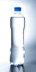 Plastic water bottle. Backlight. White blue tone. Side view.