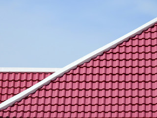 pink tile roof of home with blue sky