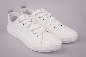 Pair of new white sneakers on white background