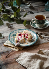 Two slices of homemade meringue roll with cream and berries