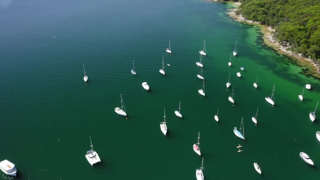 Rising aerial view of the Davis Marina revealing Sydney Harbour entrance and the Manly Ferries on clear blue day.
