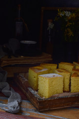 Homemade corn cake with tangerines on dark background. Traditional Brazilian sweet pie. Cornbread. Style Dark Moody.