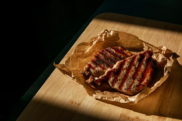 grilled pork steaks on a piece of crumpled parchment