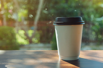 take away cup for hot coffee drink put on wooden table in cafe