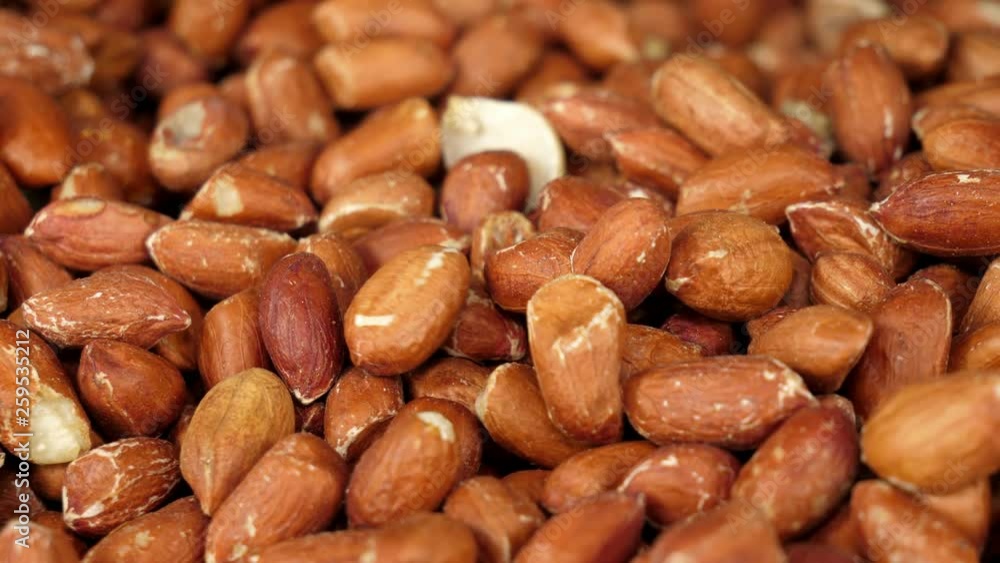 Poster closeup of a batch of peanuts as more are added to the pile. background