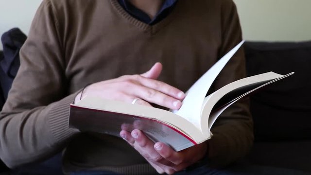 A man reading a book on his couch