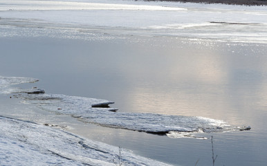 River in the early spring morning. Ice and snow on the river bank.