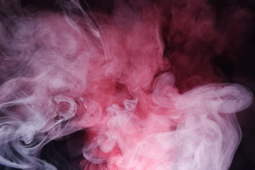 Bright colored smoke rises on a black background.