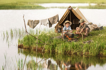 Two boys kindle a fire on the lake