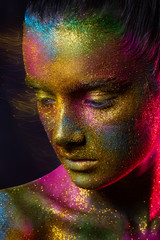 Beautiful girl in colorful bright sequins and colorful lights posing in the Studio . Art design colorful bright makeup
