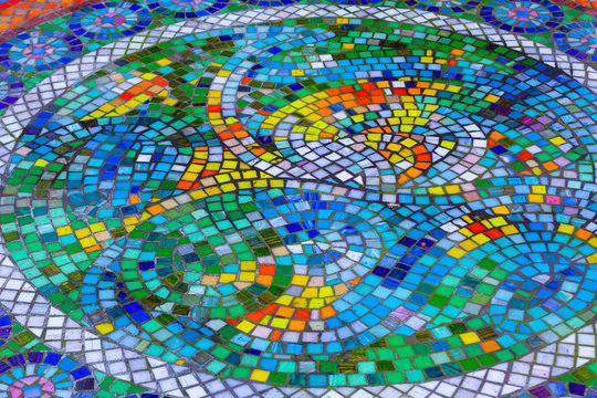 Colorful mosaic with bright yellow, orange, green and blue stones,