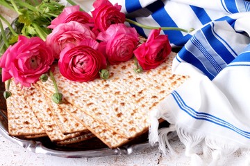Matzo and prayer sahwl in front of ranunculus 