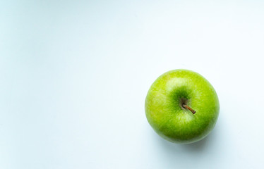 green apple on a white-blue background place for an inscription