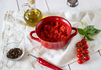 Chopped tomatoes with olive oil on a white background. Top view