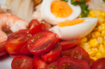 closeup of roma tomatoes and hard boiled eggs in a plate