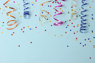  Festive background of ribbons and confetti on a colored background top view.