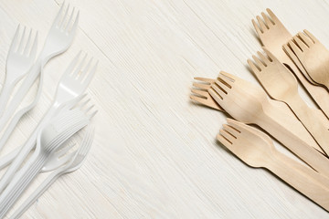 Disposable tableware from natural materials, wooden spoon, fork, knife, environmentally friendly. Comparison of plastic and wooden utensils. Place for text 