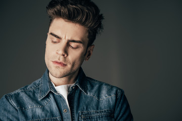 handsome and brunette man looking away isolated on black