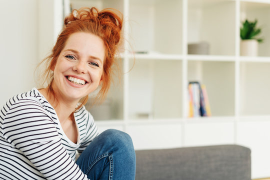 Smiling woman on couch with copy space
